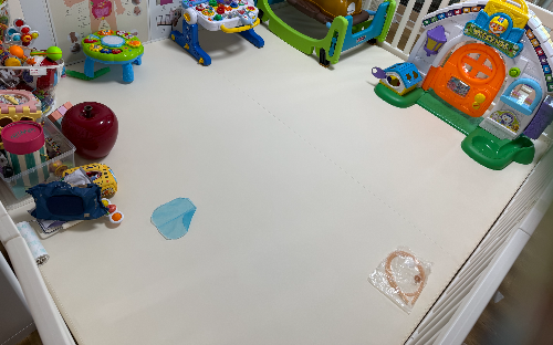 베이비룸 울타리 안에 접이식 매트가 깔린 거실 사진