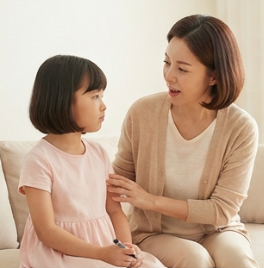 엄마가 딸 옆에서 다정하게 이야기하는 모습