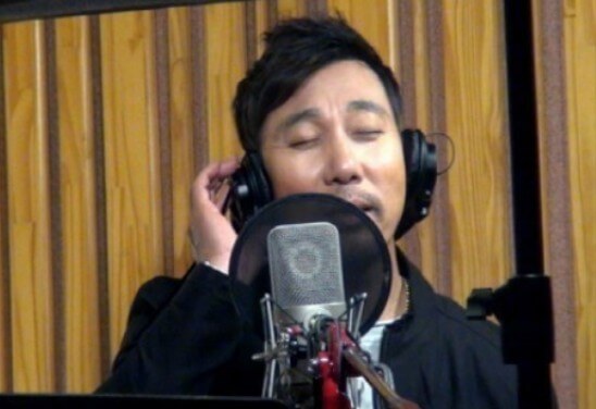 이문세가-슬픔도-지나고-나면을-녹음하고-있는-사진으로-녹음용-마이크-앞에서-헤드폰을-끼고-노래를-하고-있는-사진