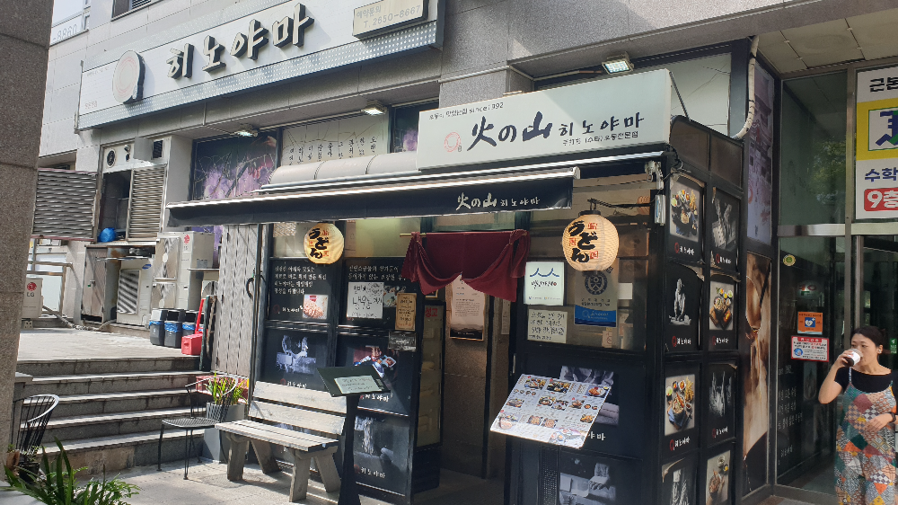 히노야마라고 쓰여있는 간판. 앞에 작은 벤치도 보인다. 입구옆에는 메뉴판이 있다.