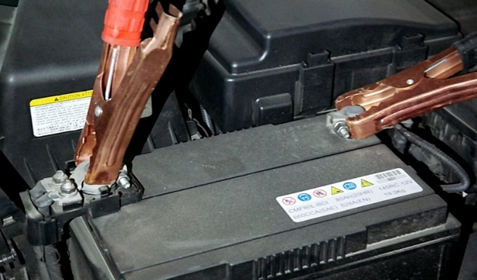 방전된 차량 배터리를 충전하고 있는 사진