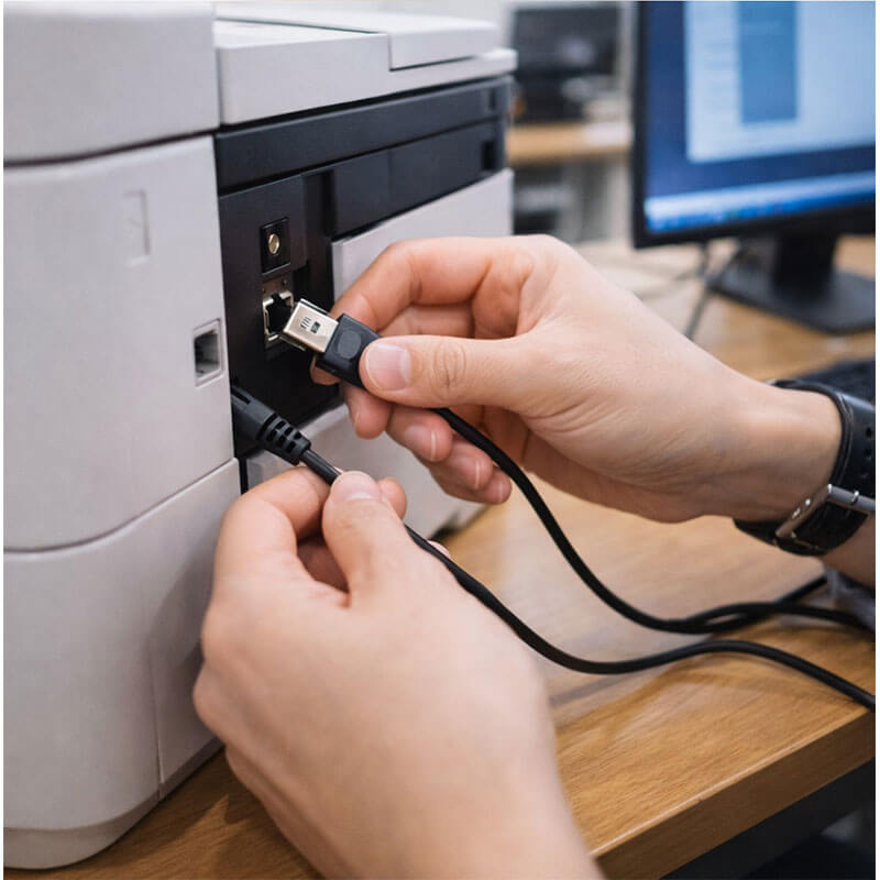 USB 케이블이나 프린터 연결 포트를 직접 확인하며 연결 상태를 점검하는 손동작 장면