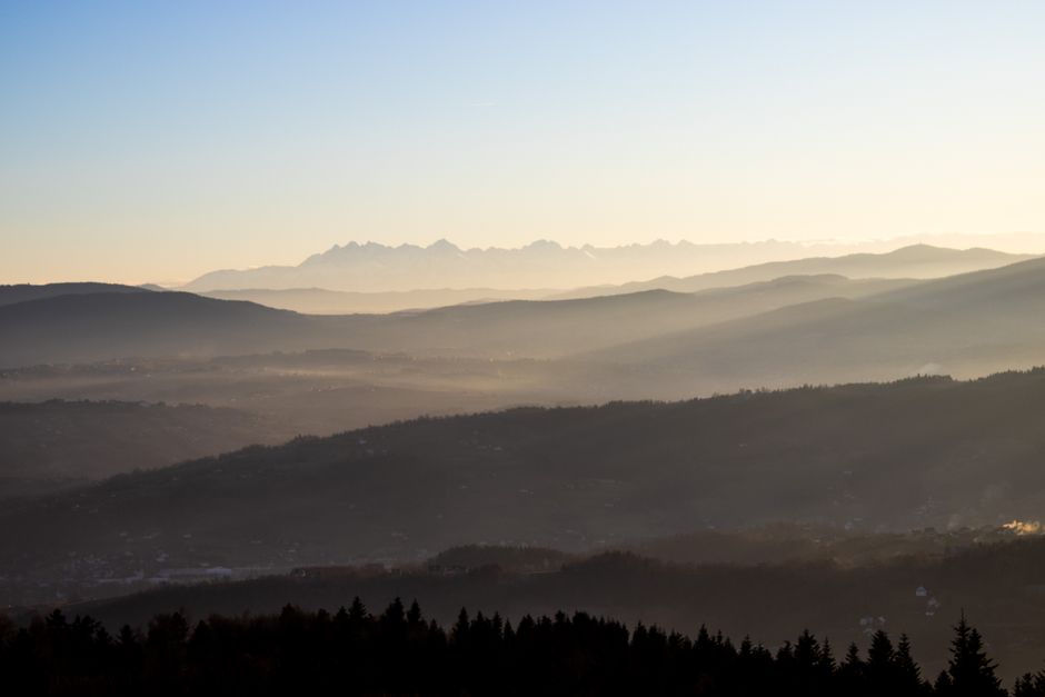 Majestic mountain range under soft morning light with misty valleys.