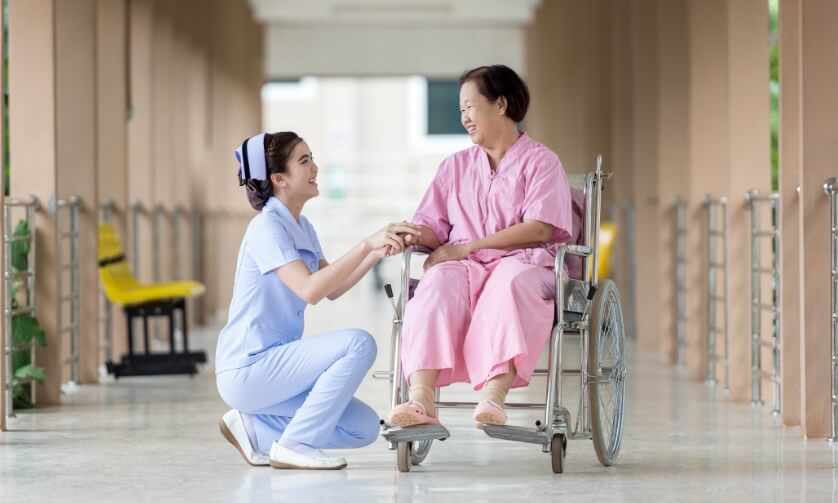 병원 복도에서 간호사가 환자를 돌봐주고 있다