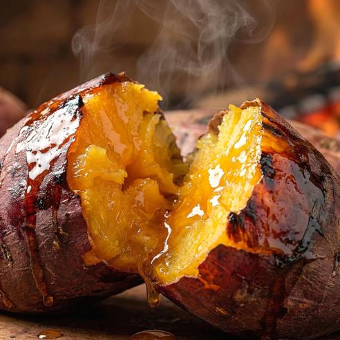 Close-up of a steaming hot roasted sweet potato split in half, revealing a soft, caramelized golden center dripping with sweet syrup
