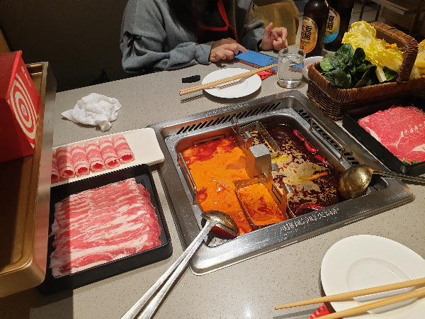 토마토와 마라탕으로 주문한 훠궈. 각종 고기들이 테이블 위에 올려져 있다.