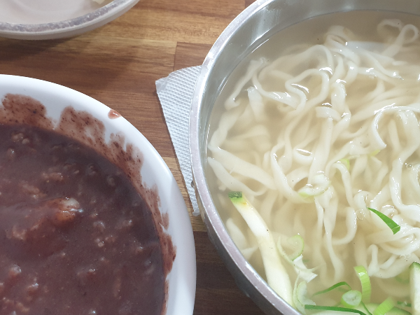 테이블 좌측에는 팥죽 우측에는 칼국수가 있다.