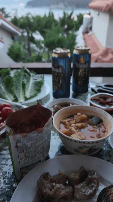 해지는-바다뷰가-보이는-테라스에-준비된-음식