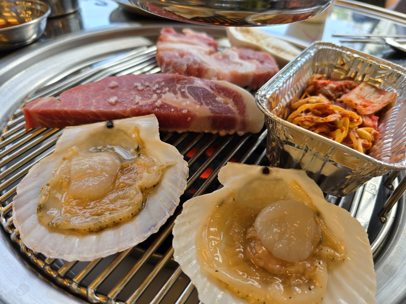 연탄불에 구워지고있는 고기와 가리비