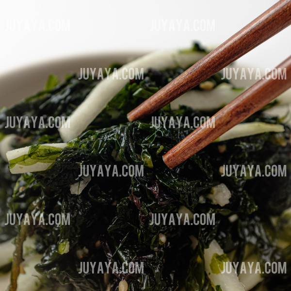 나물과 함께 젓가락으로 집은 무 채소&amp;#44; 푸른 나물과 하얀 무 조각이 조화롭게 어우러진 모습.