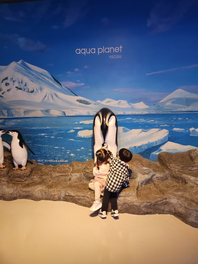 펭귄 모형 앞의 아이들