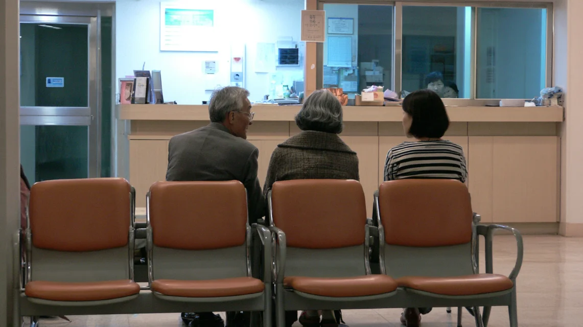 병원 대기실 접수창구 앞에서 조용히 순서를 기다리는 사람들
