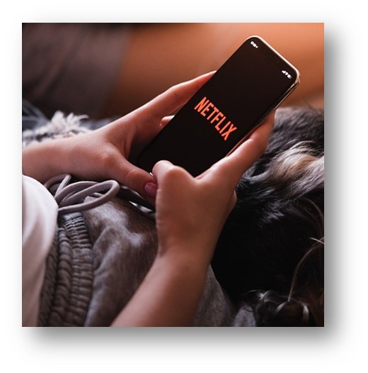 넷플릭스 앱을 스마트폰에 설치해서 영화를 보려고 하는 여자의 모습