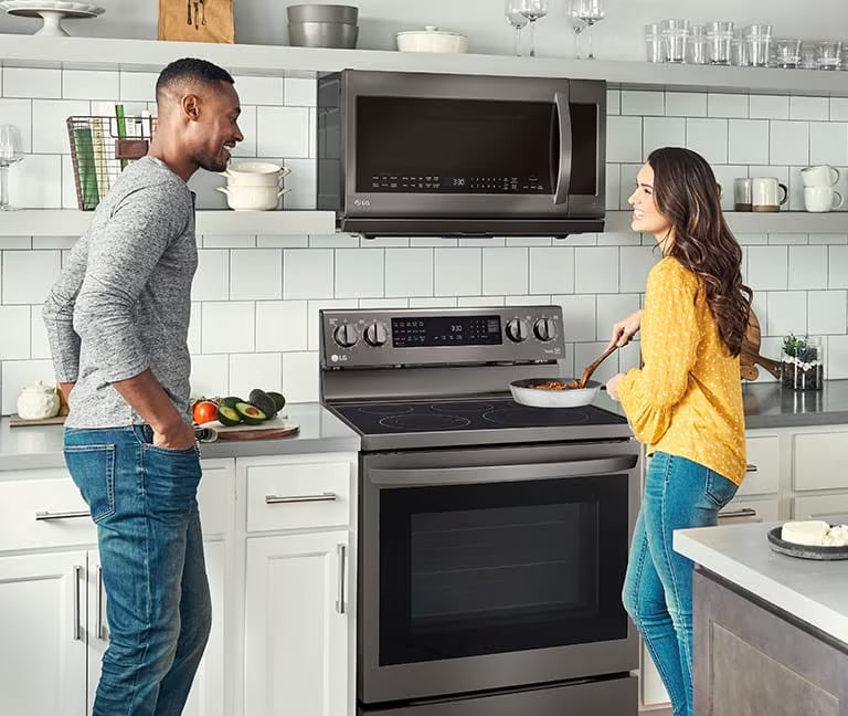 에너지 효율적인 가전제품이 갖춰진 주방에서 즐거운 시간을 보내는 가족. 에너지 절약의 이점을 보여줍니다.