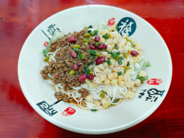 다진 고기, 병아리콩, 땅콩, 파 등이 풍성하게 올라간 중국식 면 요리. 현지식의 매운맛과 비주얼을 함께 담고 있습니다