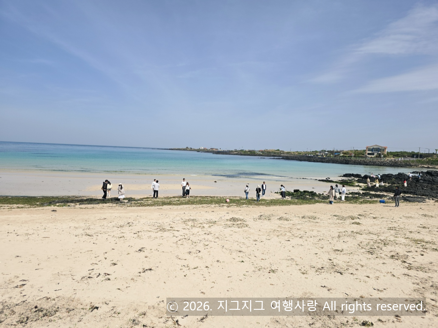 눈이 시리도록 맑은 에메랄드빛 바다와 하얀 모래사장이 넓게 펼쳐진 제주 우도 해변의 평화로운 풍경