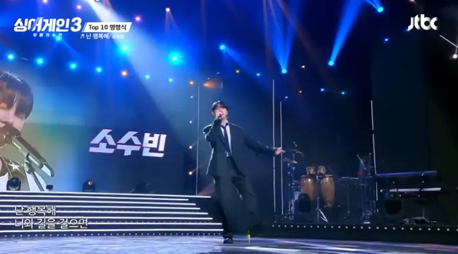 싱어게인3-
검은양복 검은 바지 흰셔츠 파란넥타이 오른손으로 마이크를 잡고 노래하는 소수빈