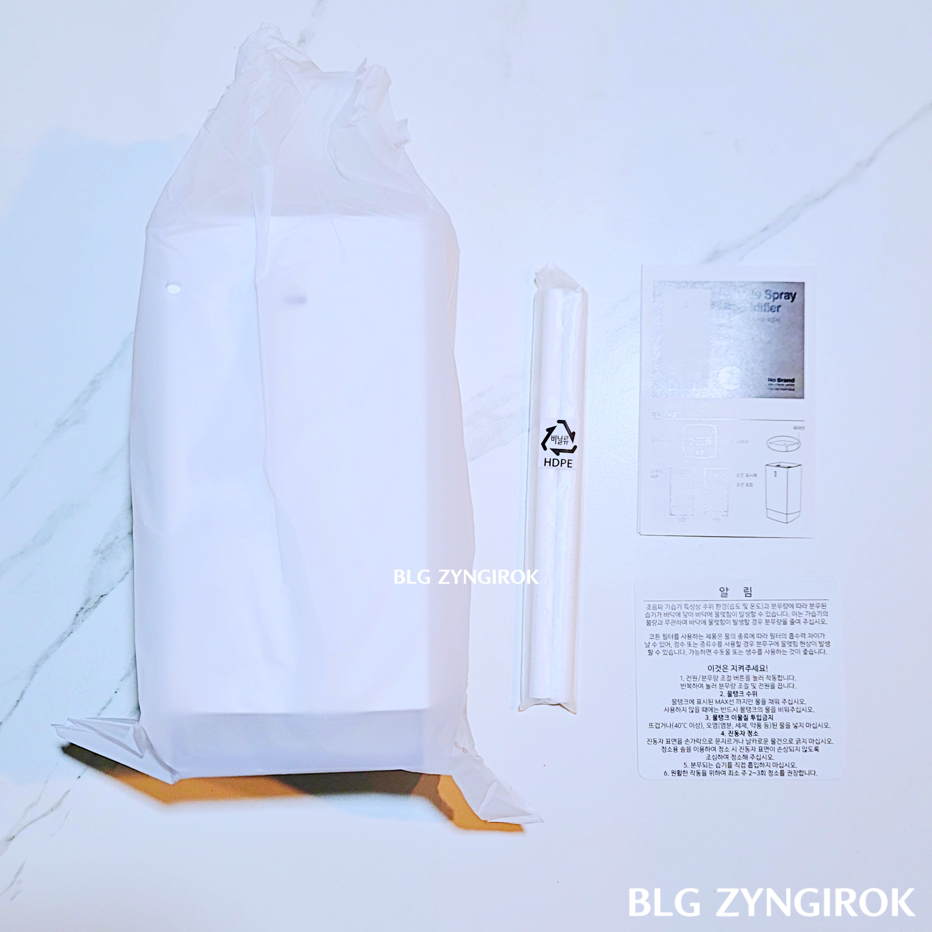 노브랜드 LED 듀얼 가습기 - 구성품들이 테이블 위에 놓여있다.