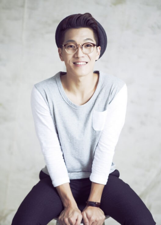 김필이-안경과-모자를-쓰고-의자에-앉아-환하게-웃고-있는-사진