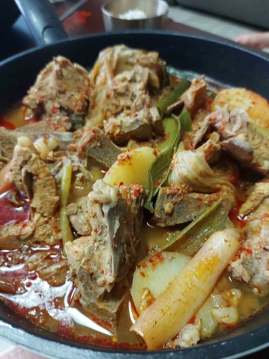 매콤하고 진한 국물의 감자탕. 돼지 등뼈, 감자, 배추, 대파가 듬뿍 들어간 한국식 전통 뼈해장국