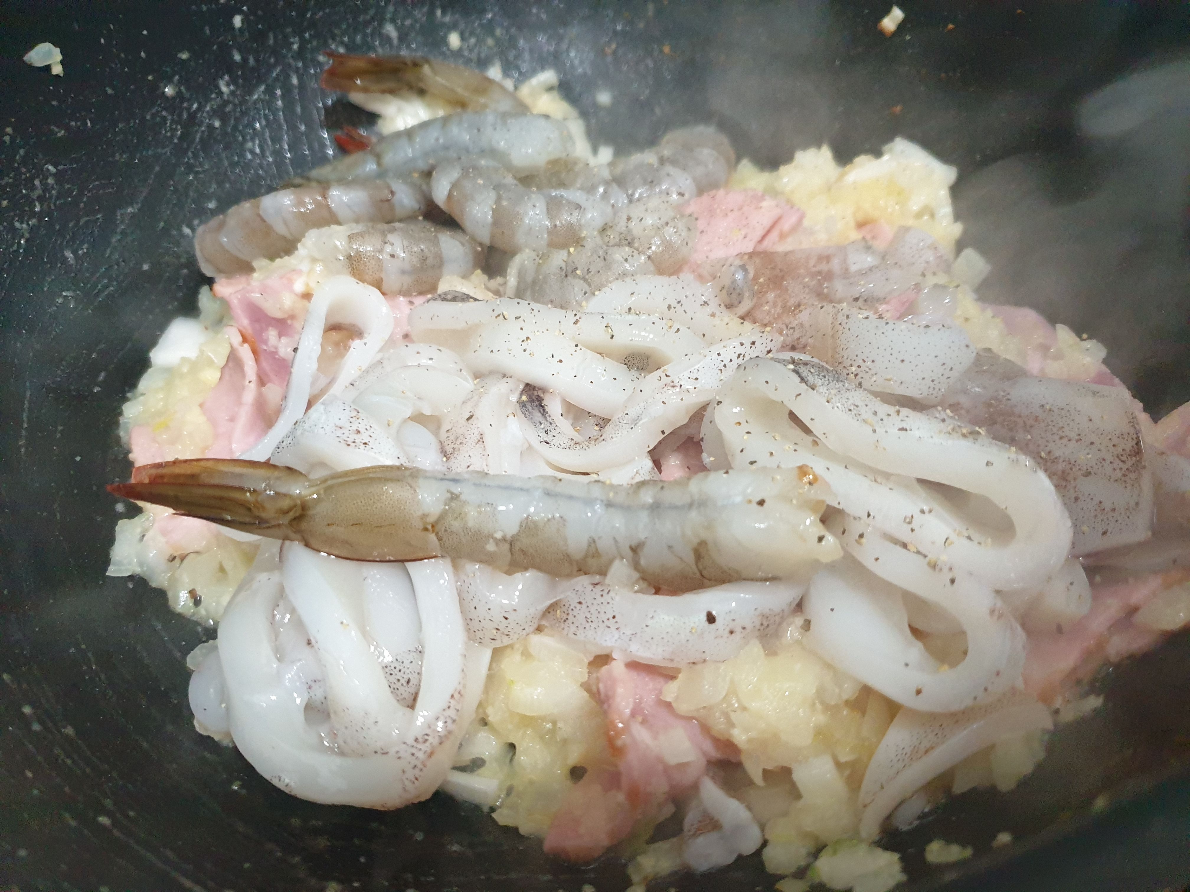 프라이팬에서 볶고있는 오징어와 새우