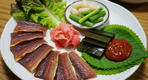 접시에 과메기, 다시마, 상추, 깻잎, 초장이 놓여 있고, 접시 가운데 생강초절임이 있음