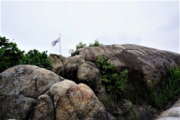 국기봉 정상 암봉에 펄럭이는 태극기, 흐린 하늘,