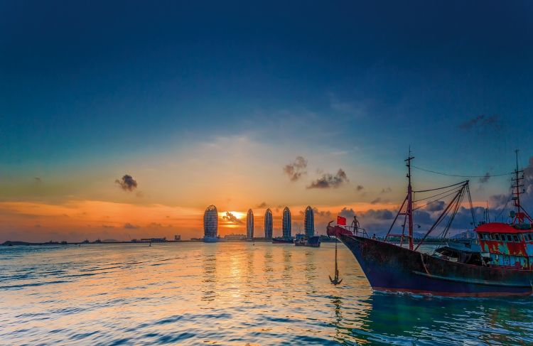 저녁노을이 붉게 물든 바다 위로 전통 배와 현대적인 건물이 어우러진 하이난 해변
야경이 아름다운 여운을 주는 순간으로 리조트가 즐비한 산야만 특유의 모습이에요