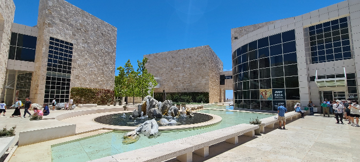 코트야드에 있는 연못. 직사각형의 연못 안에 물이 있고&amp;#44; 가운데로 동그란 모양의 구조물과 동상이 있다. 