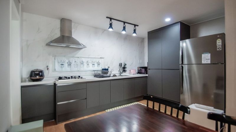 그레이 톤 싱크대와 세련된 조명이 설치된 완성 후 주방