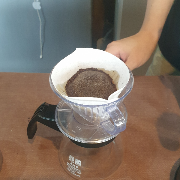 서버위에 올려져 있는 칼리타 드리퍼 안의 커피 파우더가 부풀어져 있다.