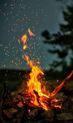 산에서-캠프파이어-불이-불씨를-날리며-활활-타오르는-모습