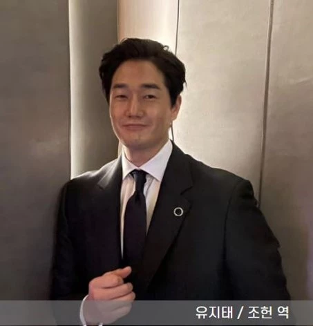 배우 유지태가 양복 입고 미소 짓는 모습