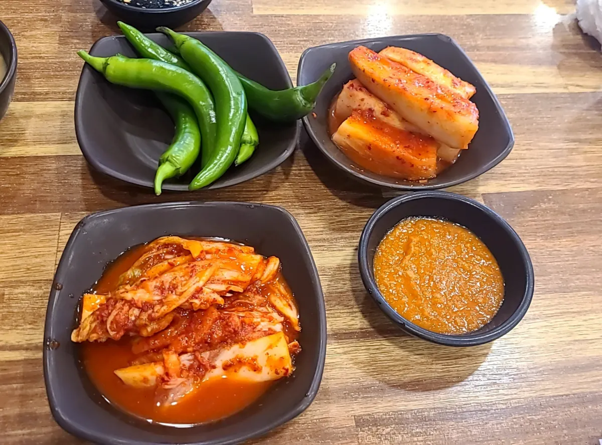 테이블위에-깍두기-배추김치-아삭이고추-쌈장