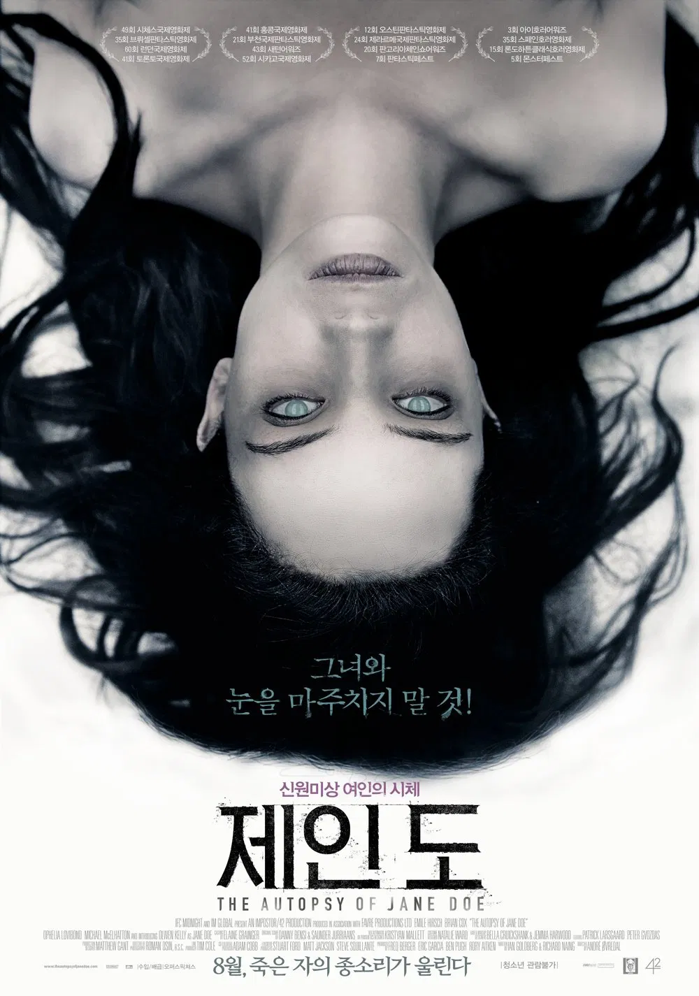 영화 '제인 도'의 포스터로, 흰 천 위에 누워 있는 여성 시신의 얼굴이 정면을 응시한 채 화면을 가득 채우고 있다. 여성의 눈동자는 창백하게 떠 있으며, 주변은 어둡고 차가운 분위기를 자아낸다. 중앙 하단에는 &quot;그녀와 눈을 마주치지 말 것!&quot;이라는 문구가 쓰여 있고, 아래에는 영화 제목 '제인 도'와 부제 '신원미상 여인의 시체'가 적혀 있다.