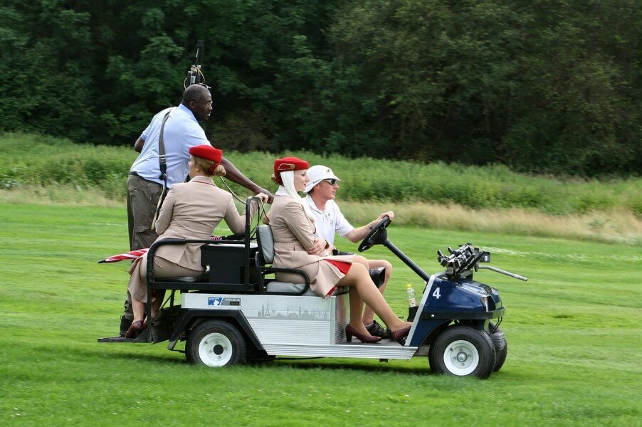 골프장에서 카트를 타고 이동하는 모습