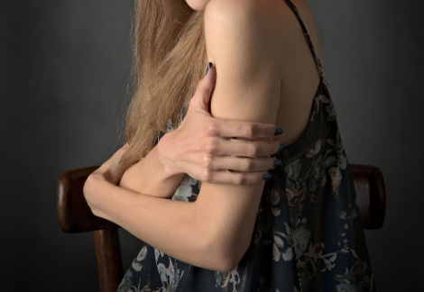 왼 팔을 감싸고 있는 여자