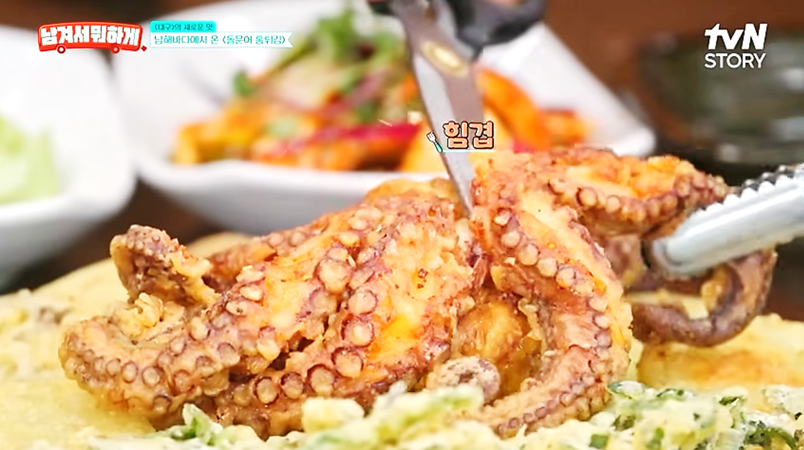 튼실한 돌문어 통튀김의 문어 다리를 가위로 자르고 있는 모습