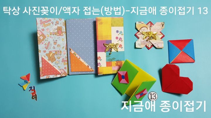 색종이로 액자 접기 방법으로 접어 완성한 모양의 표지에는 딱지 접기 또는 하트 접기 등을 접어 붙여 장식할 수 있습니다.