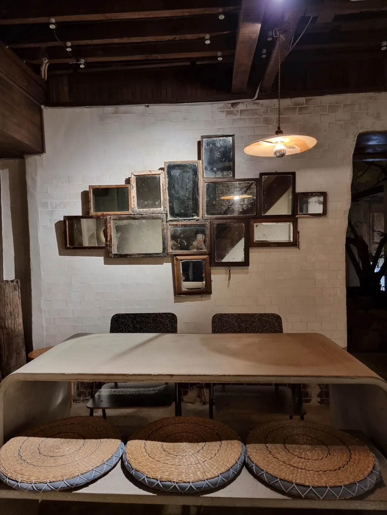 벽-거울-액자-여러개-천장에-조명-그아래-테이블