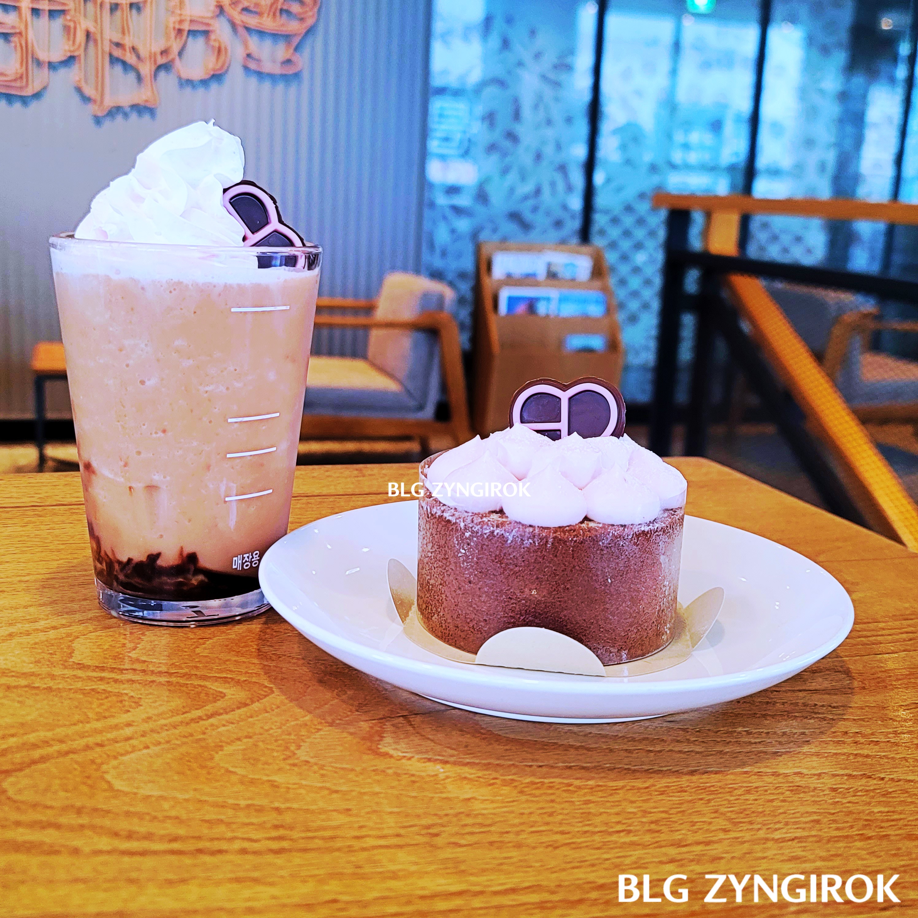블랙핑크 프라푸치노와 바움쿠헨이 테이블 위에 놓여있다.