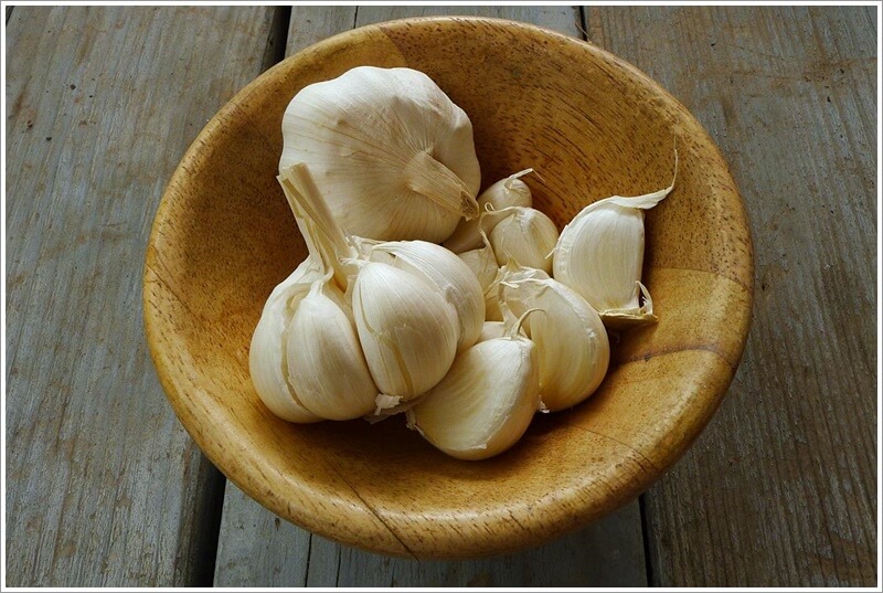 황토색 그릇에 담겨져 있는 깐마늘과 안깐마늘