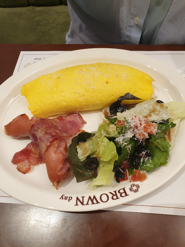 맛있게 부풀어 오른 계란과 샐러드 그리고 베이컨이 있는 오믈렛