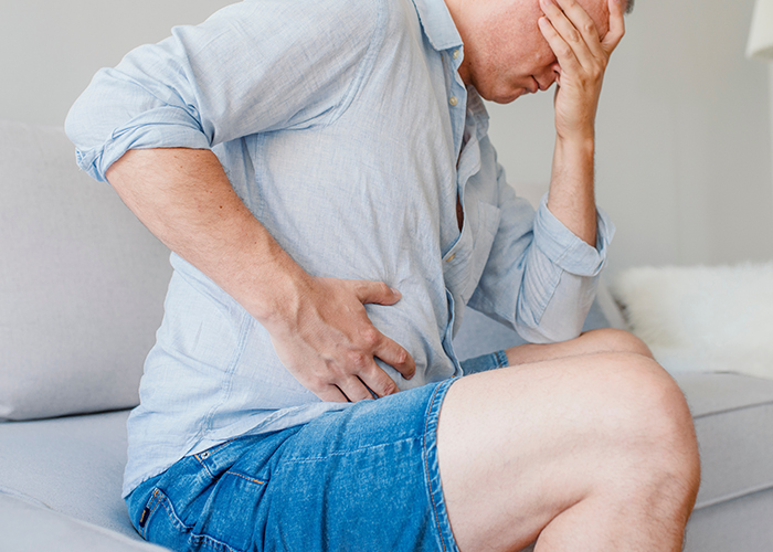 성인 남성이 오른쪽 복부를 쥐고 고통스러워 하고 있다
