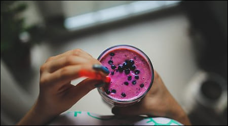 블루베리 스무디 한 잔 들고 있는 손