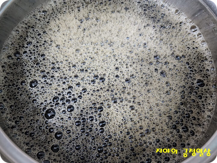 냄비에 부은 검은색이 나는 소스의 거품들