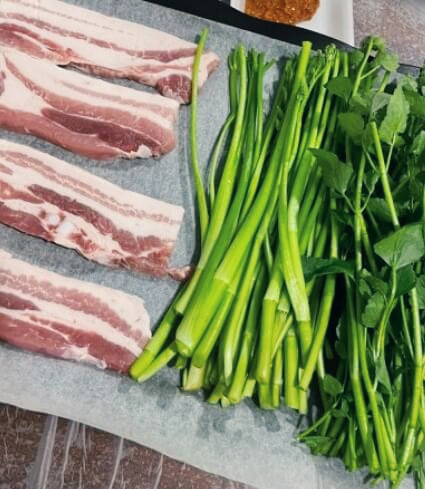 미나리와 삼겹살이 놓여져 있다