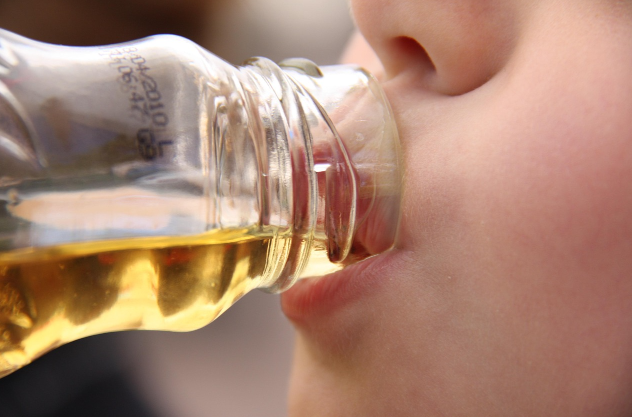 유리병에 담긴 음료를 마시고 있다