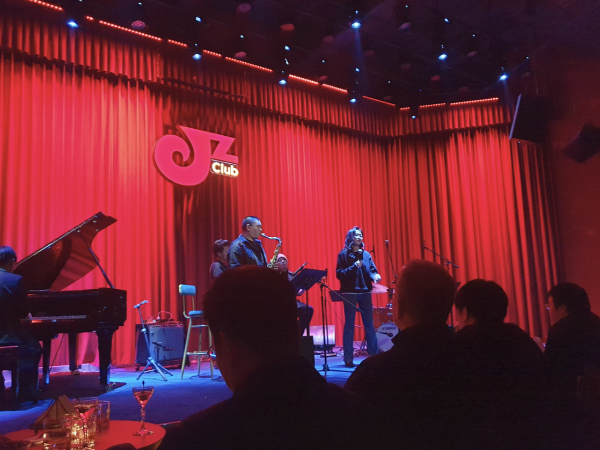 붉은 조명 아래에서 공연 중인 밴드.