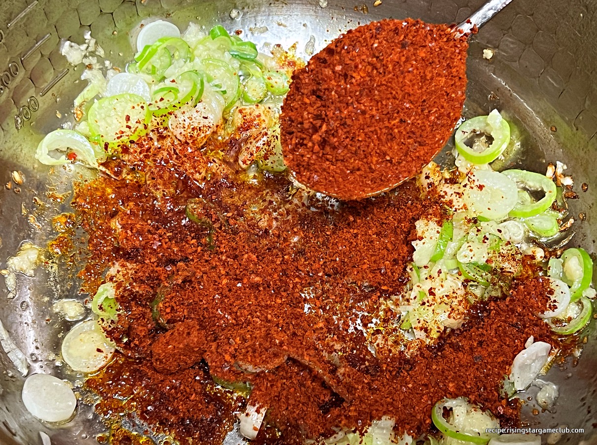 순두부 찌개에 들어갈 고추기름을 만들기 위해 볶은 마늘과 파에 고춧가루를 넣은 사진